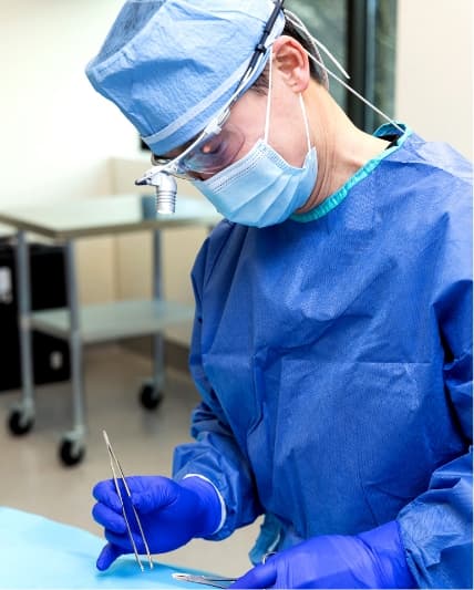 Dr. Chan, fully dressed in surgical gear, prepares to perform a surgical procedure.