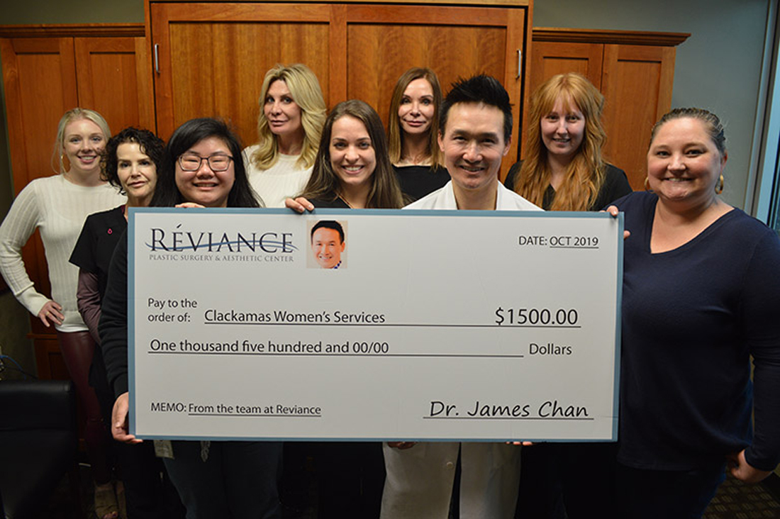 Dr. Chan and his staff holding a donation check for Clackamas Women's Services